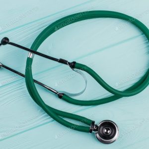 Green stethoscope on a light blue wooden surface