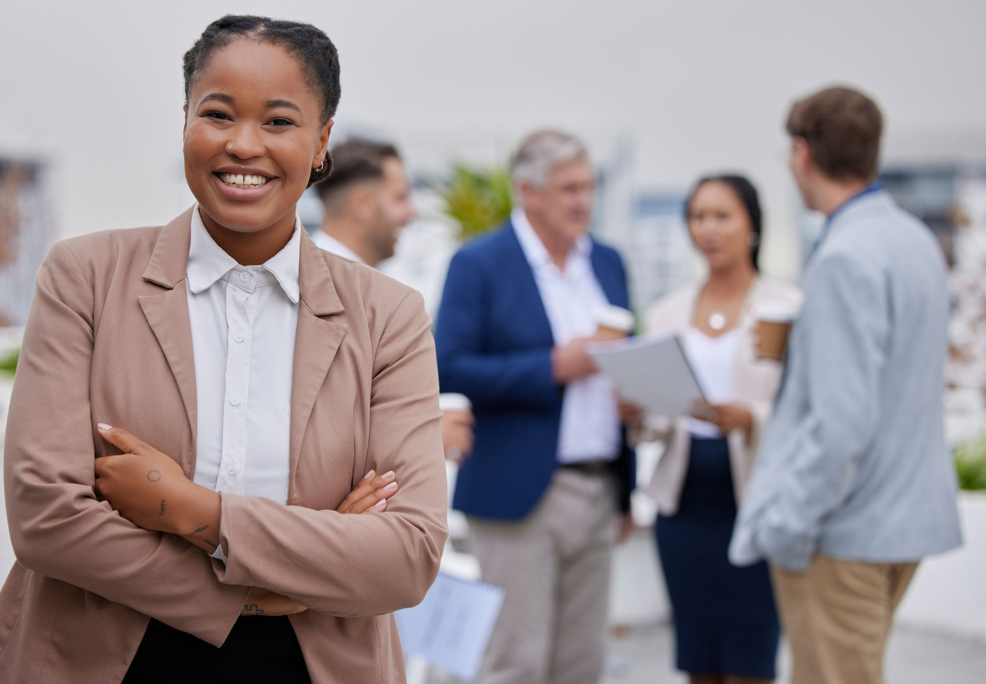 Smiling woman in a business suit standing in front of a group.