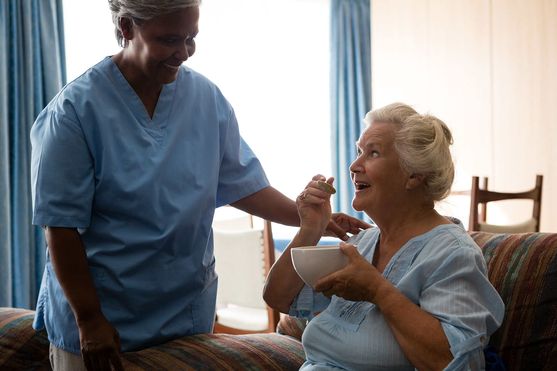 Caregiver Assisting Senior Woman with a Meal